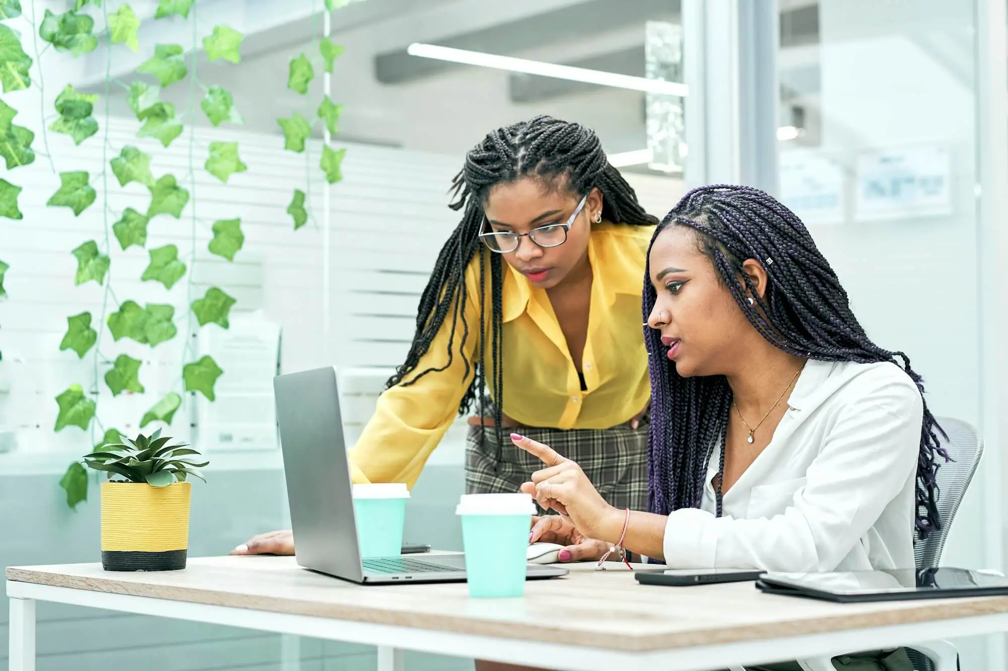 two-young-black-women-reviewing-analytical-data-on-various-electronic-devices-